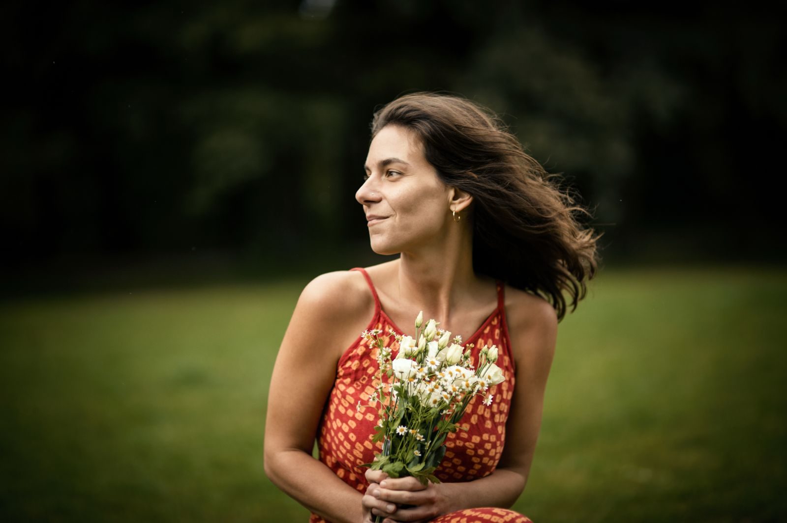 Shila Morelli sorridente in abito rosso con un mazzo di fiori